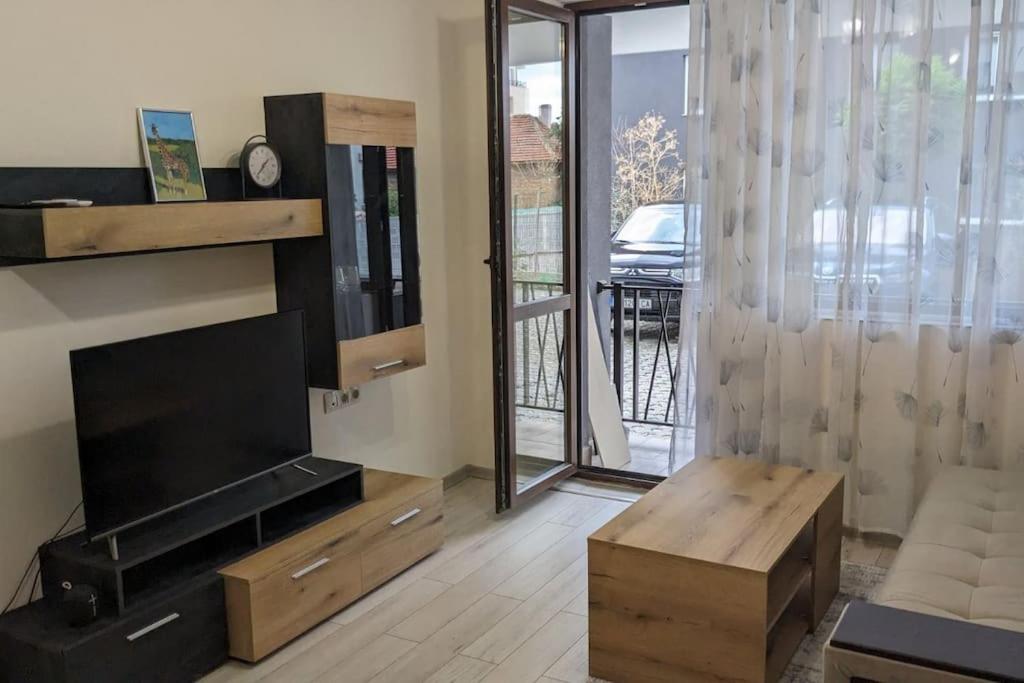 een woonkamer met een flatscreen-tv en een tafel bij Сарафово Център in Boergas