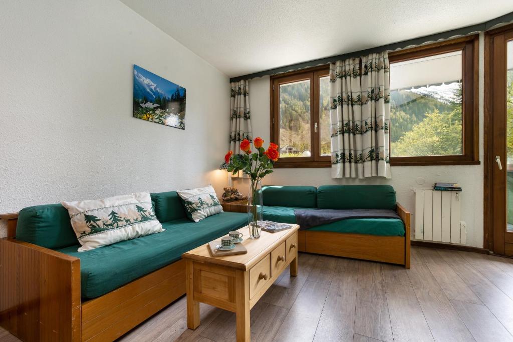 a living room with a green couch and a table at Chamonix Sud - Jonquilles 38 - Happy Rentals in Chamonix-Mont-Blanc