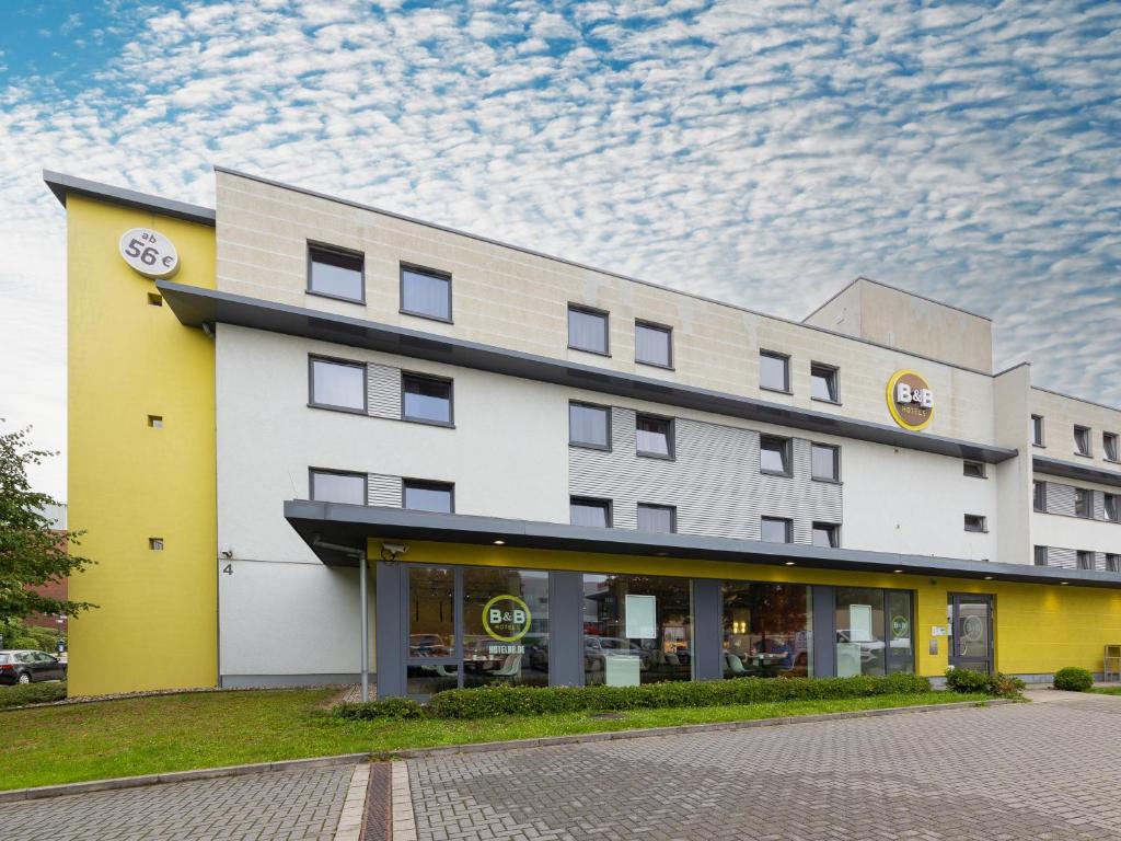 un edificio de hotel con un cielo nublado en el fondo en B&B Hotel Essen, en Essen