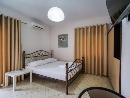 a bedroom with a bed and a television in it at Vironas Hotel in Himare