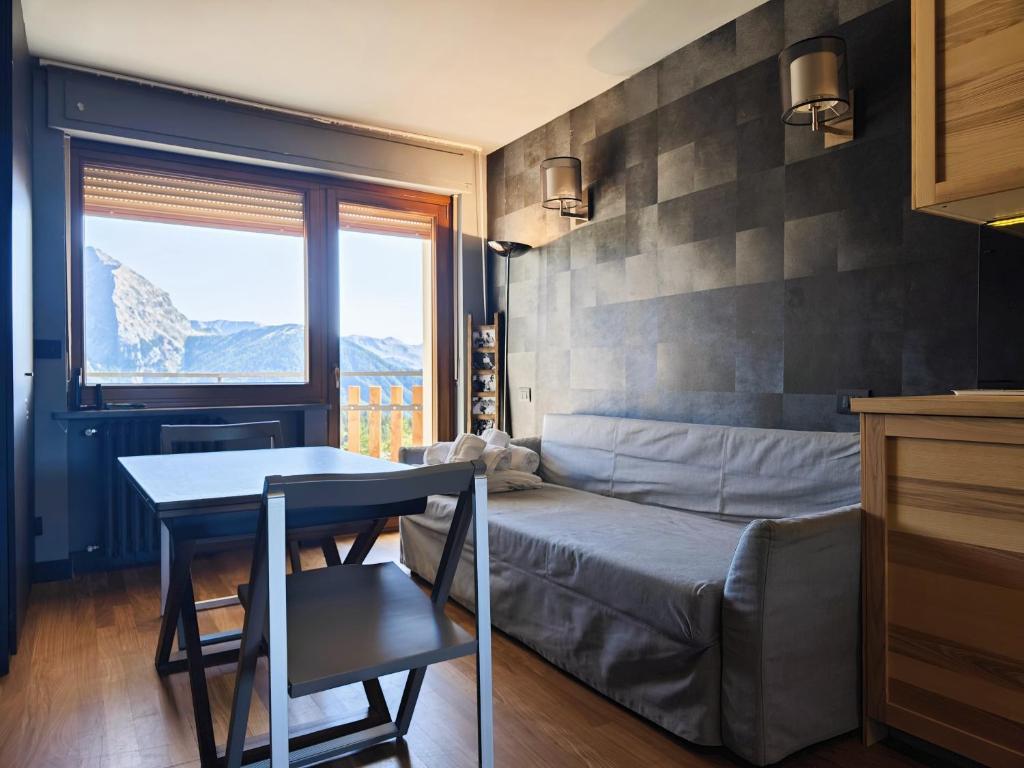 Schlafzimmer mit einem Bett, einem Tisch und einem Fenster in der Unterkunft Hostdomus - Oak Luxury Suite in Sestriere