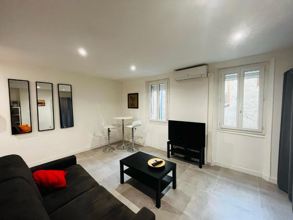 uma sala de estar com um sofá e um piano em Le Paradis - Vieux Port, Studio avec climatisation em Marselha