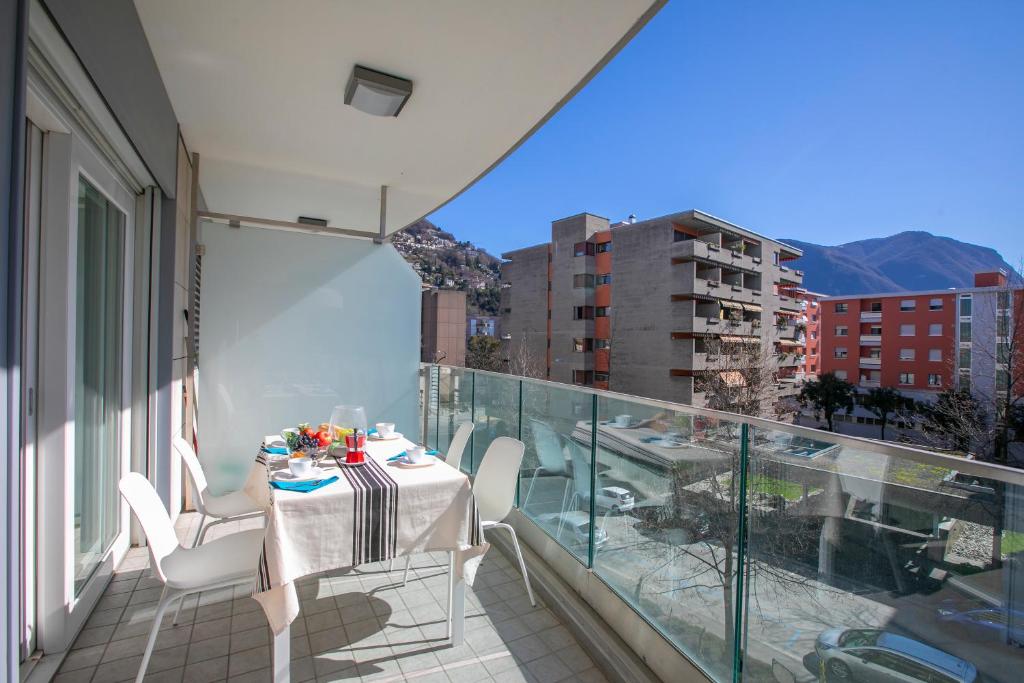 a balcony with a table and chairs on a balcony at Prestige du Lac 27 - Happy Rentals in Lugano