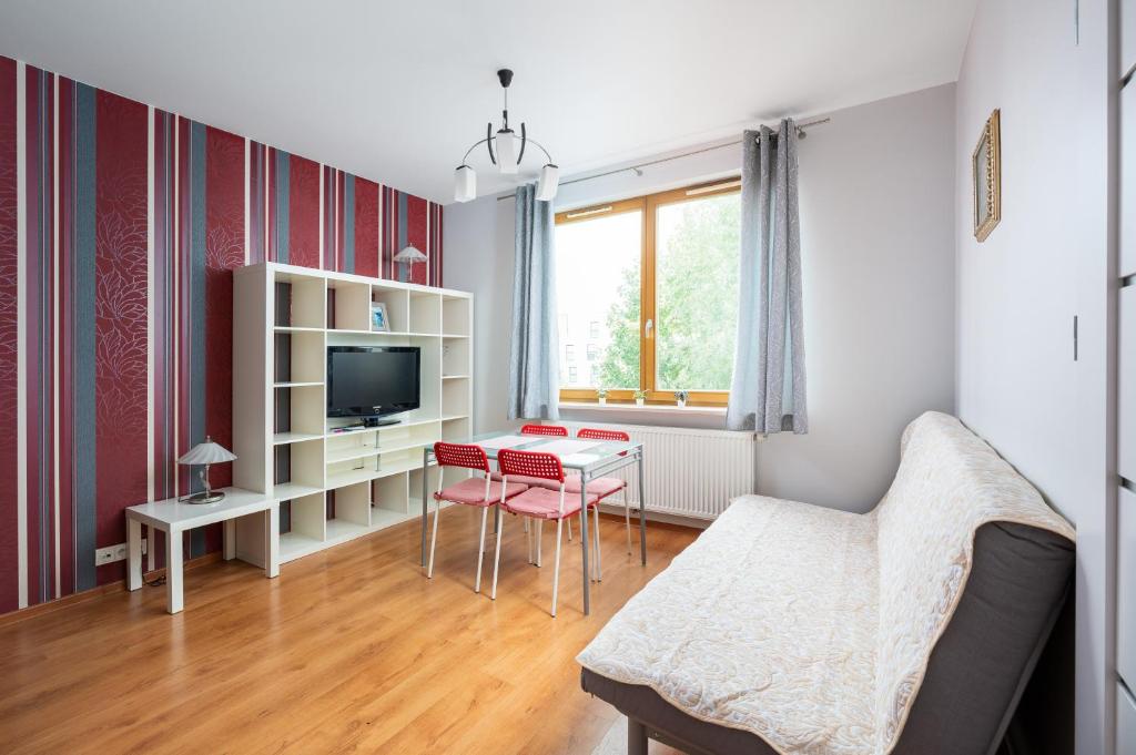 a living room with a couch and a table at Obrzeżna Standard Apartment in Warsaw