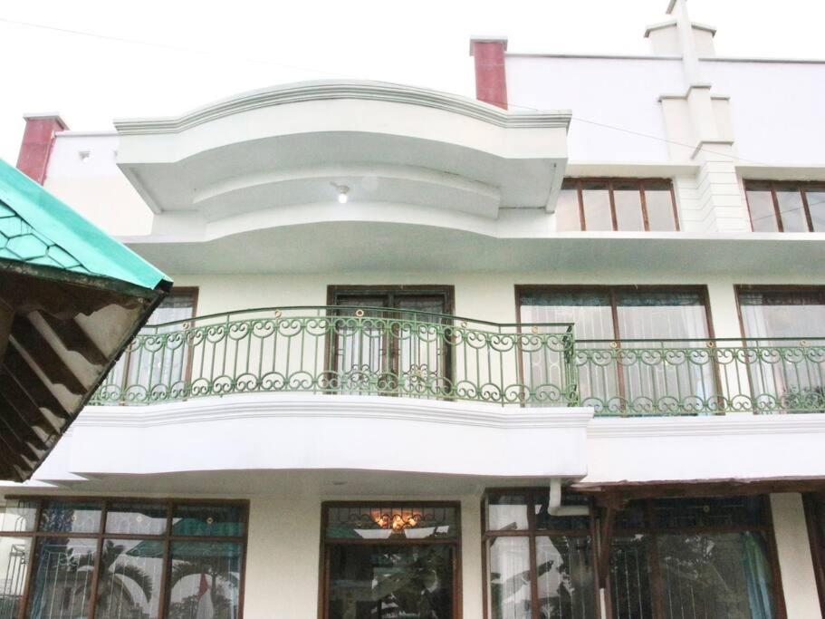 - un bâtiment blanc doté d'un balcon avec une croix dans l'établissement Villa Hijau Bandungan, à Bandungan