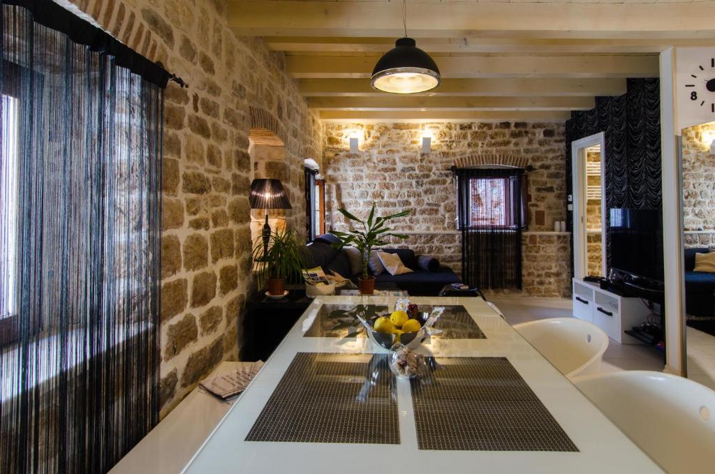 a living room with a table and a brick wall at Apartment Capo Family & Capo Studio -Old Town-Parking in Trogir