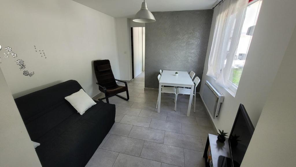 - un salon avec un canapé et une table dans l'établissement La maison dans le jardin, à Viry-Châtillon