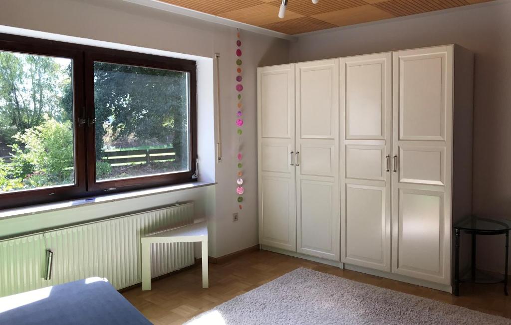 1 dormitorio con armarios blancos y ventana en Woanders zu Hause 4 Sterne FeWo, en Kölbingen