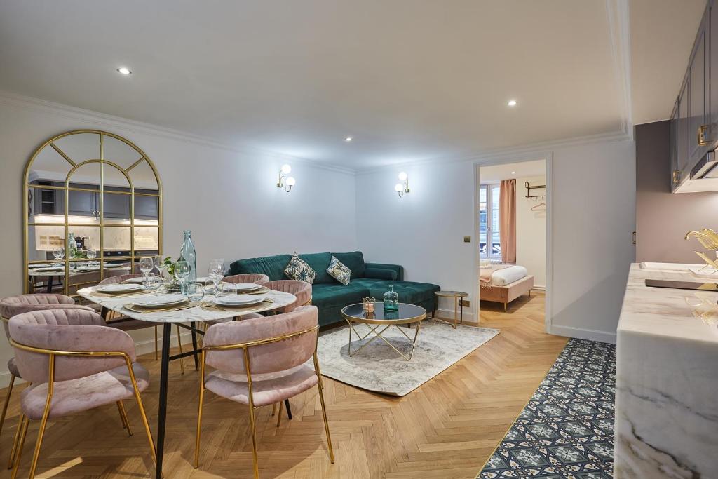 un salon avec un canapé vert et une table dans l'établissement Apartment Saint Germain des Près by Studio prestige, à Paris