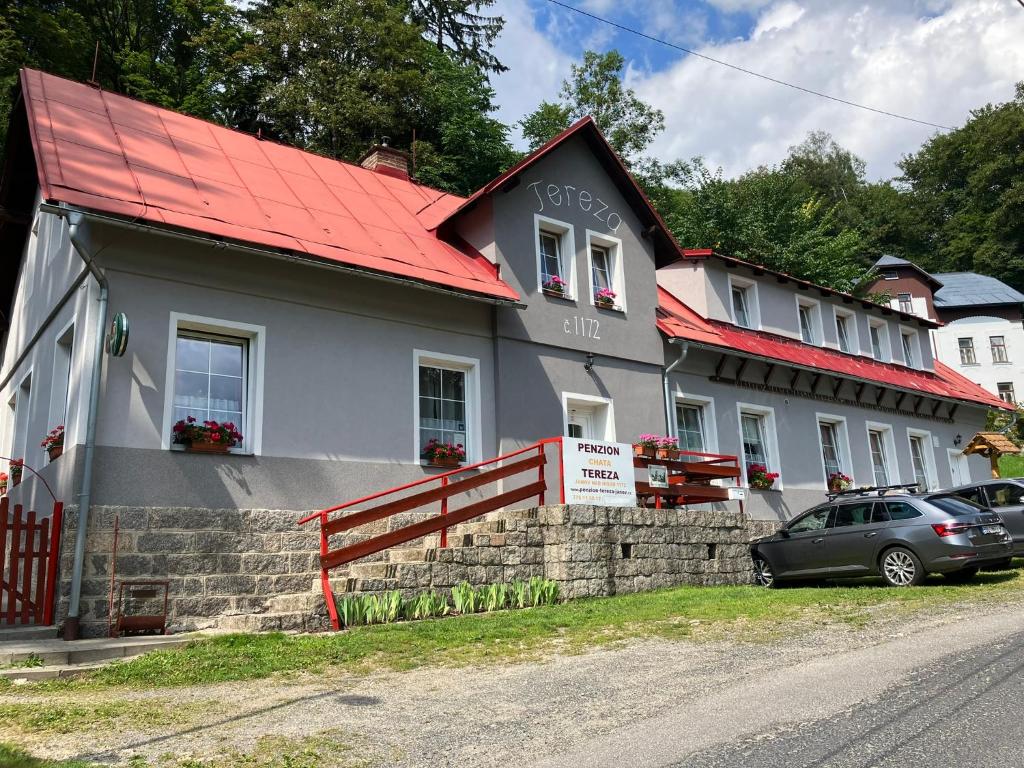 a house with a red roof and a car parked in front at Chata Tereza in Janov nad Nisou