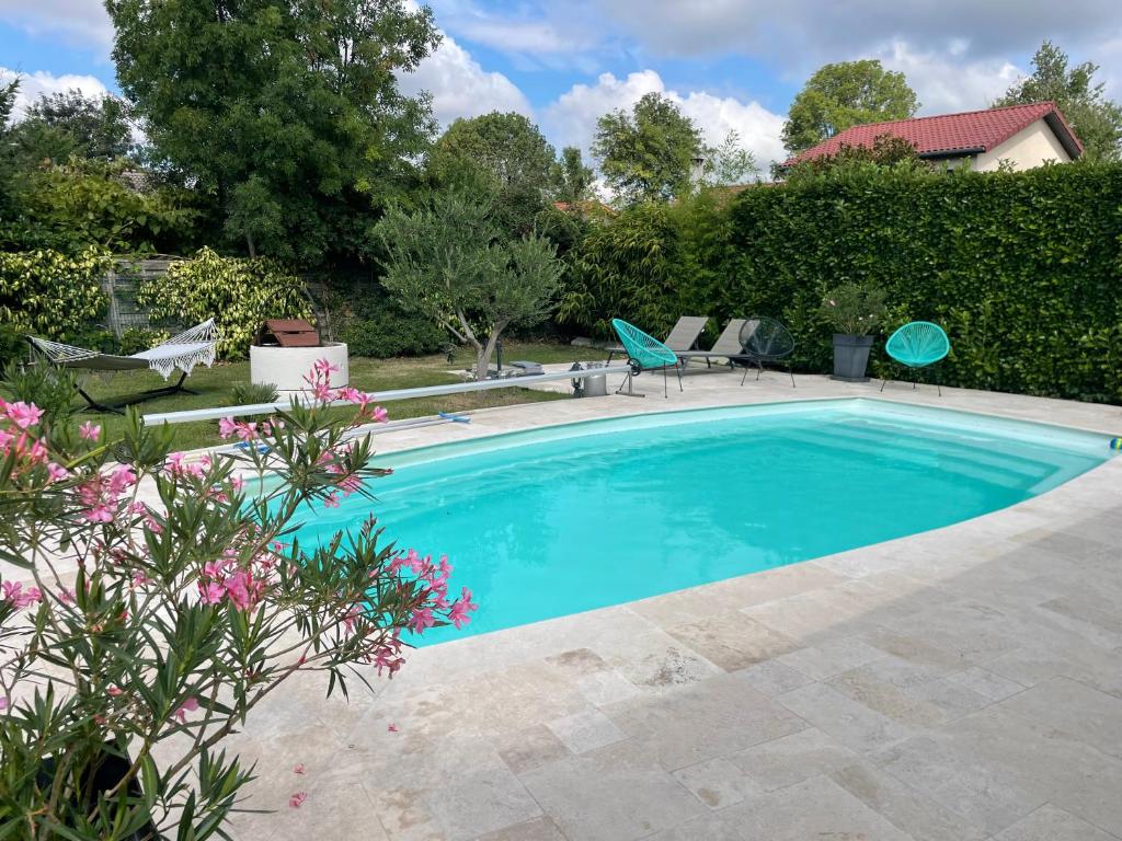 a large swimming pool with chairs and a yard at Villa poétique proche de Lyon in Saint-Marcel-en-Dombes