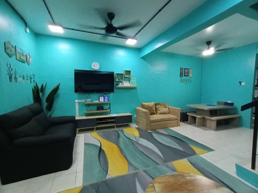 salon z niebieskimi ścianami i telewizorem z płaskim ekranem w obiekcie The Handz House II with WIFI - For family or same gender only w mieście Kepala Batas