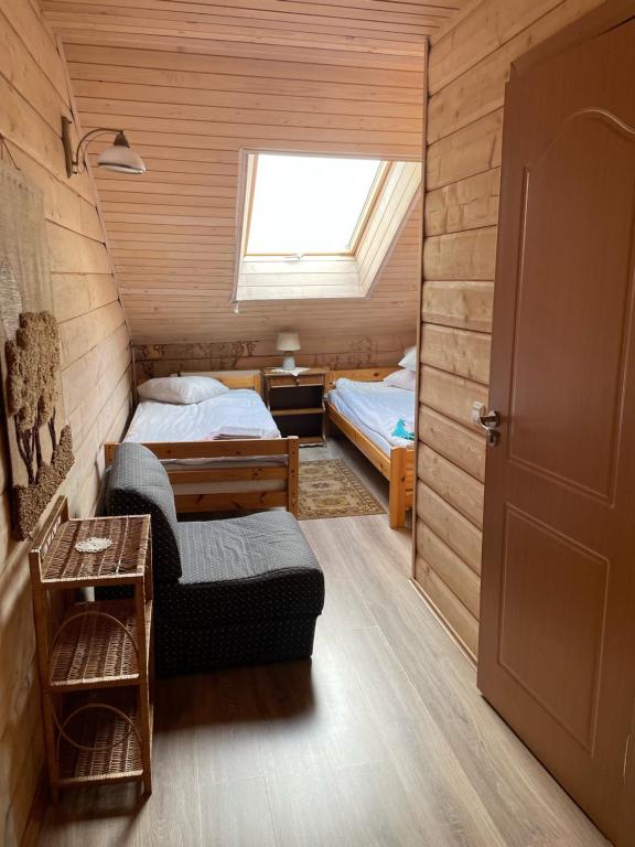 a small room with two beds and a window at Kurėnų Užeigos Svečių Namai in Kurėnai