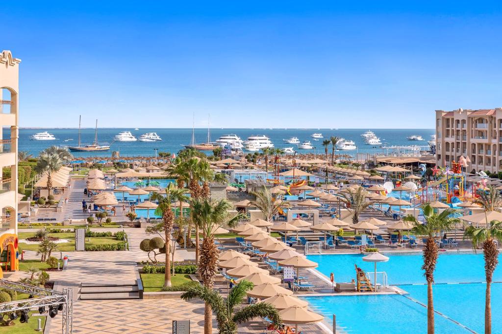 a view of a resort with a pool and umbrellas at Pickalbatros White Beach Resort - Hurghada in Hurghada