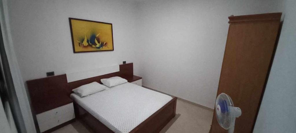 - une petite chambre avec un lit et une photo sur le mur dans l'établissement Apartamento Avenida, à Sal Rei