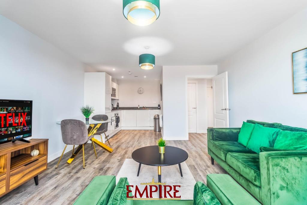 Una sala de estar con un sofá verde y una mesa. en 1 Bedroom Apartments in Digbeth, en Birmingham