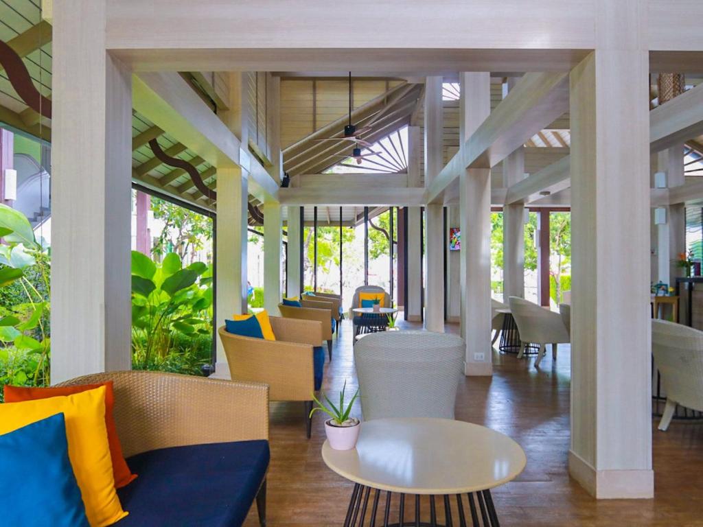 a lobby with chairs and tables in a building at Amari Koh Samui in Chaweng