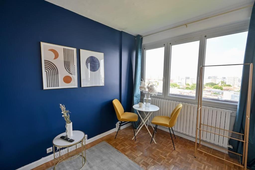 - un salon avec des murs bleus, une table et des chaises dans l'établissement Studio Paris 14ème arrondissement - II, à Paris