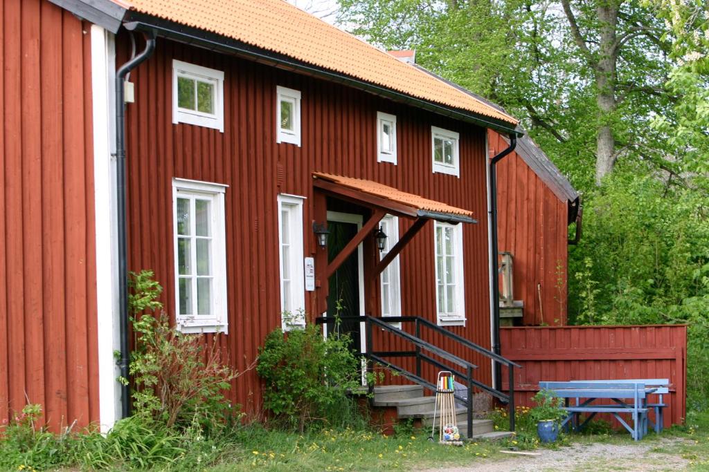 une maison rouge avec un escalier devant elle dans l'établissement Ryttarbostaden, à Enköping