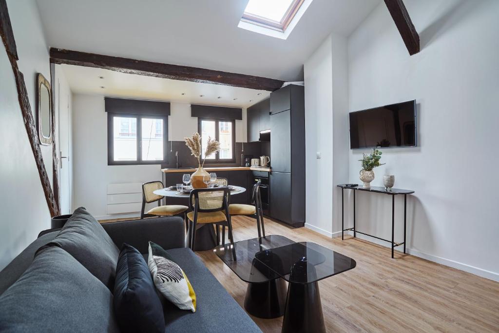 een woonkamer met een bank en een tafel bij Apartment Le Marais by Studio prestige in Parijs