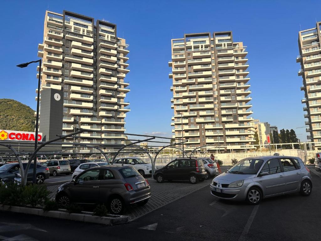 un gruppo di auto parcheggiate in un parcheggio con edifici alti di Panama Room Arechi a Salerno