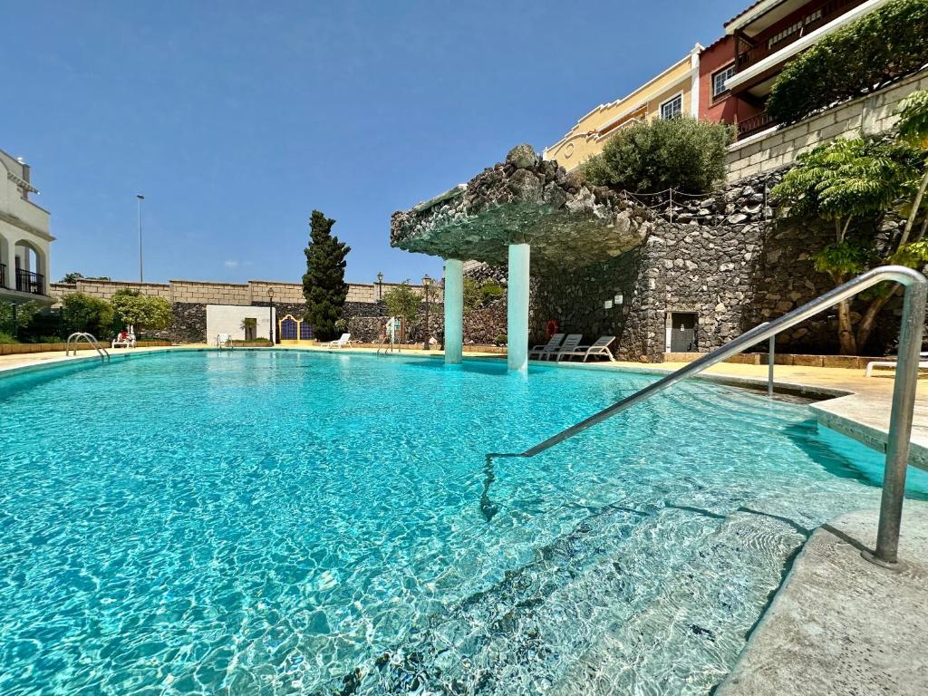 einem großen Pool mit blauem Wasser vor einem Gebäude in der Unterkunft Biltmore Relax House in San Miguel de Abona