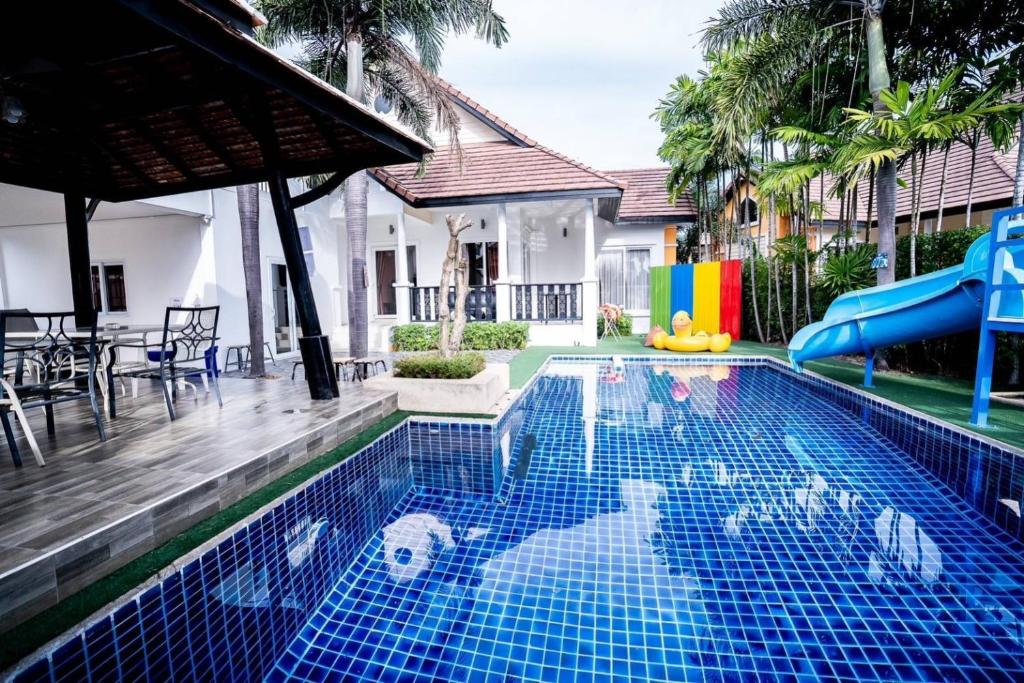 a swimming pool with a slide in a house at Pattaya 6 bedroom pool villa in Jomtien Beach