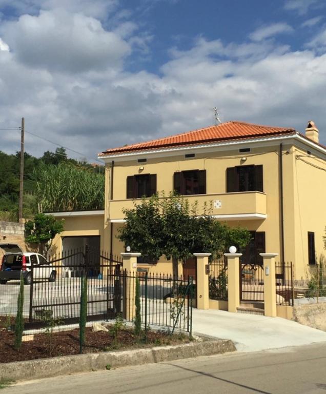 a yellow house with a fence in front of it at Villa Rosaria in Tollo