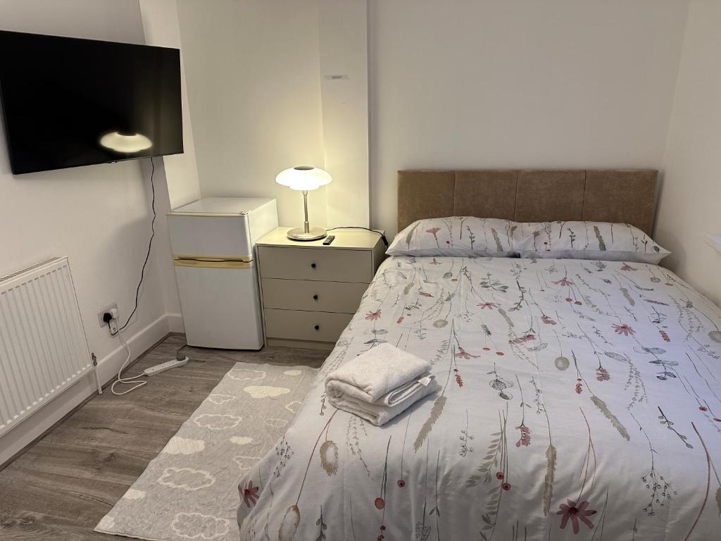 um quarto com uma cama e uma televisão na parede em PUREWAYS em Southampton