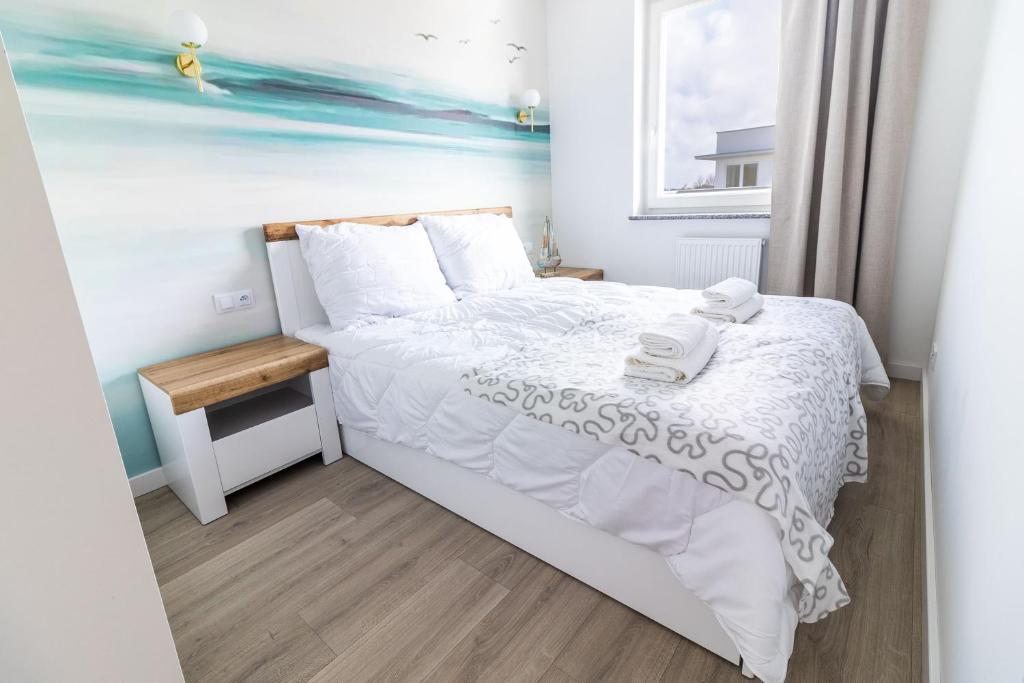 - une chambre avec un lit blanc et une fenêtre dans l'établissement Może morze, à Kołobrzeg