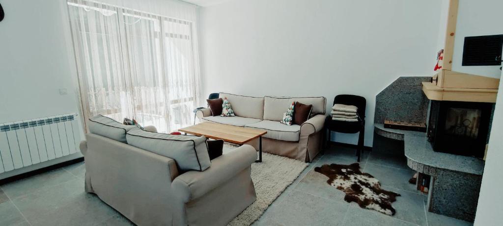 Mountain Pearls Home 9 في Vodata: غرفة معيشة مع كنبتين ومدفأة