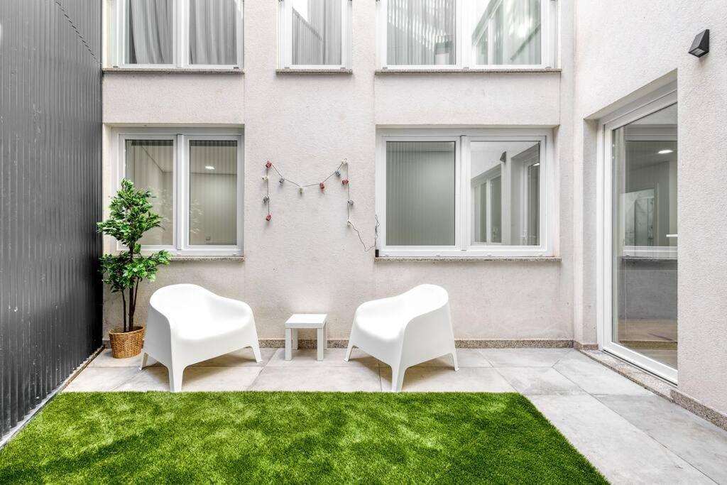 2 sillas blancas en un patio frente a un edificio en Cosy flat, Braga city center, en Braga