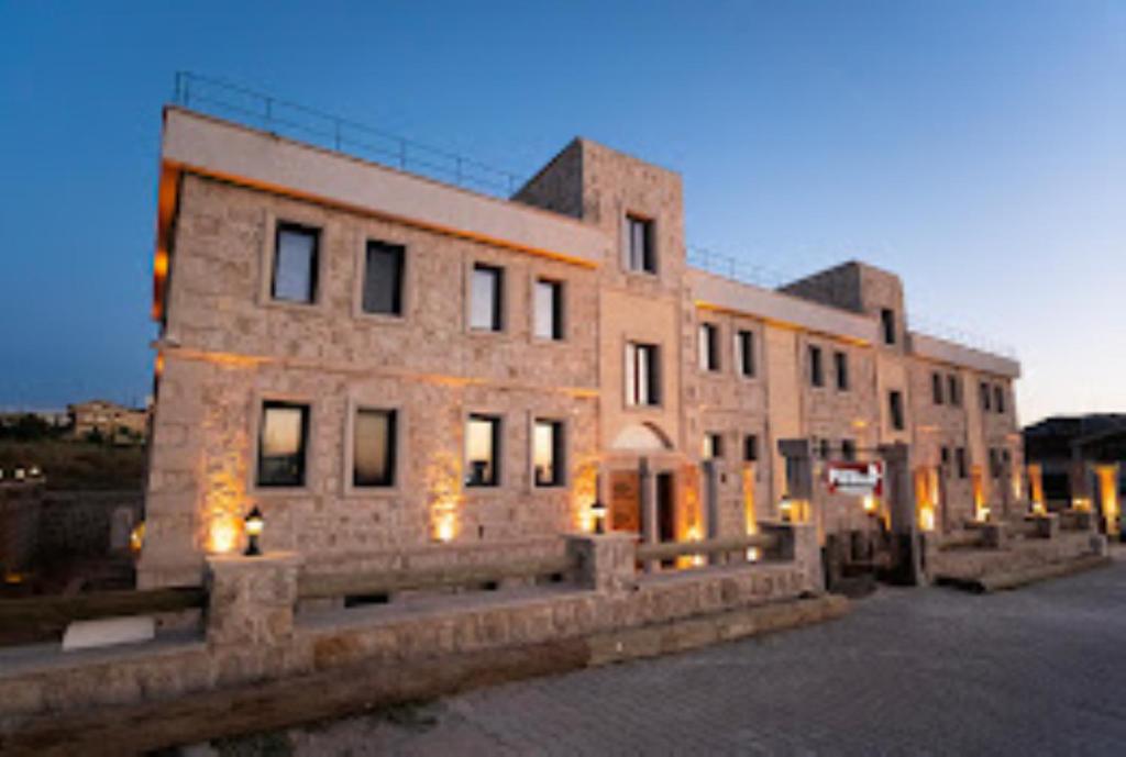 a large brick building with lights in front of it at Uçhisar Premium in Nevsehir
