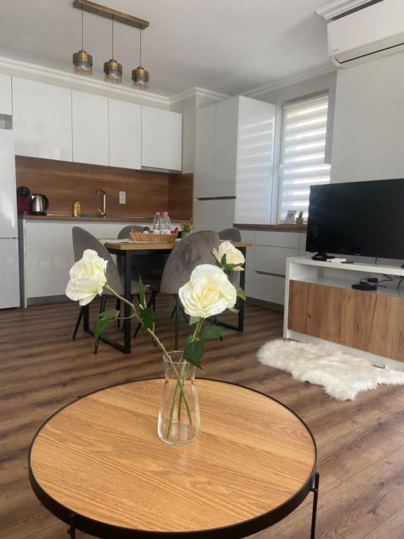 a living room with a vase with flowers on a table at M&M Center Apartment with free parking in Plovdiv