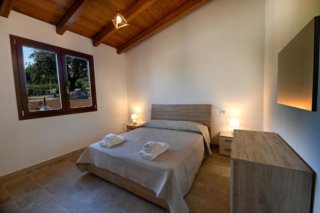 een slaapkamer met een bed met twee handdoeken erop bij Boara Resort in Mottola
