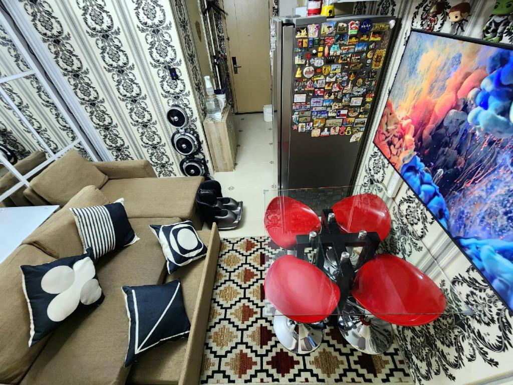 a living room with a couch and red chairs at High-Tech Studio at Grass Residences -2 persons only, Quezon City in Manila