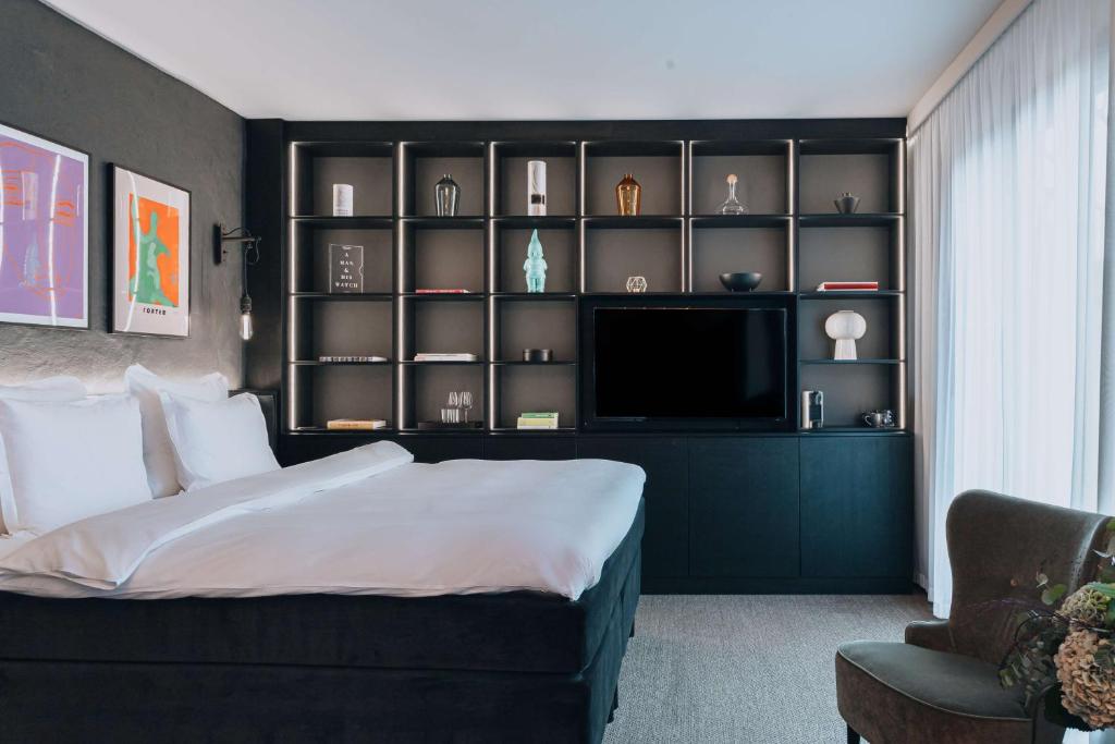 1 dormitorio con 1 cama grande y TV en Story Hotel Riddargatan, part of JdV by Hyatt, en Estocolmo