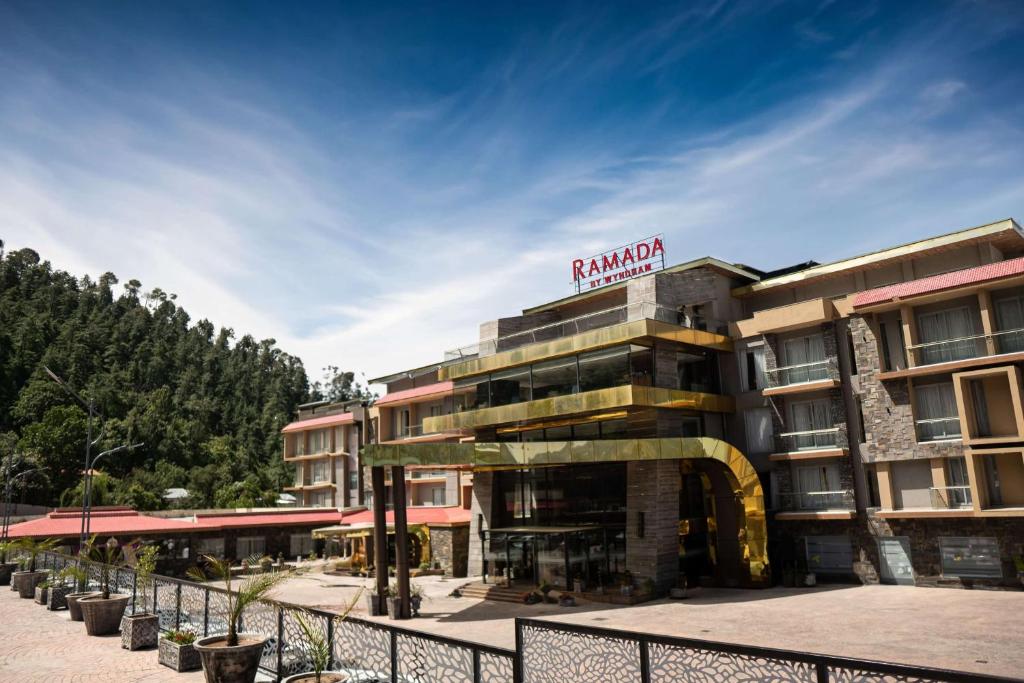 a hotel with a sign on top of it at Ramada by Wyndham Murree Lower Topa Resort in Murree