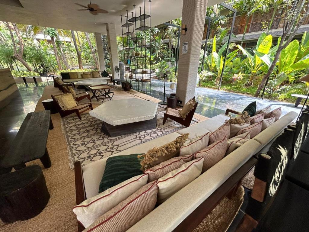 Soul Nest-Pyramid Valley International Bengaluru في بانغالور: غرفة معيشة كبيرة مع أريكة وكراسي طويلة