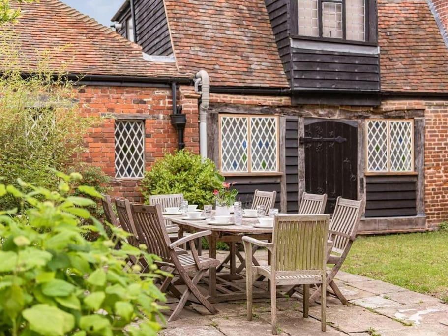 uma mesa de madeira e cadeiras em frente a uma casa em Townhouse with cathedral views em Kent