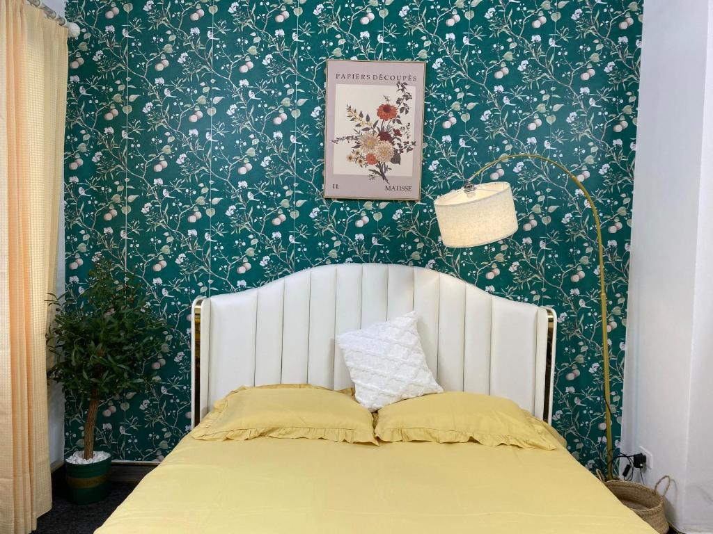 a bedroom with a bed with green and white wallpaper at FlowerGod Apartments - BlackPink HomeStay in Hanoi