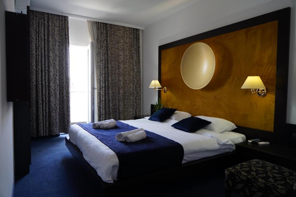 InđijaにあるApartments 29の大きなベッドと窓が備わるホテルルームです。