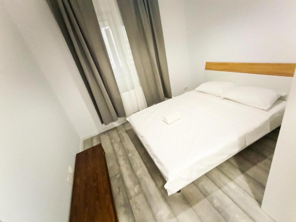 een kleine slaapkamer met een bed en een raam bij Preciziei Retreat Ap with parking and self check in in Boekarest