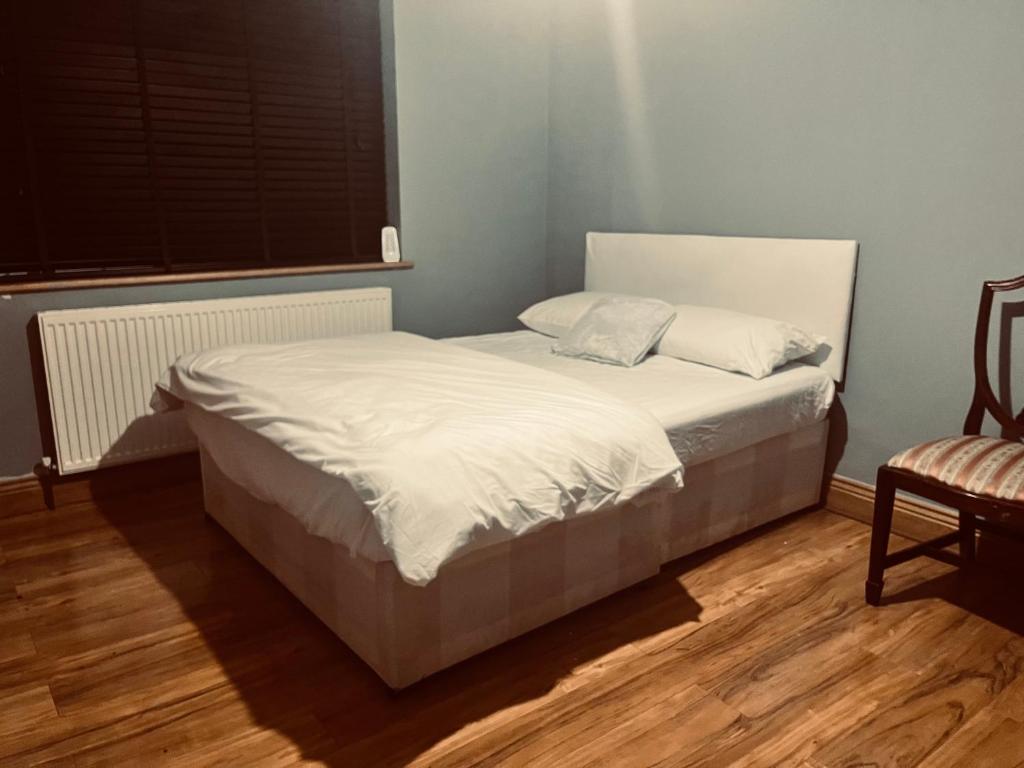 una camera da letto con un letto con lenzuola bianche e una finestra di Adorable 2 Bedroom Couple and Family-Friendly Home in Clacton-on -Sea - Coastal Comforts Retreat a Clacton-on-Sea