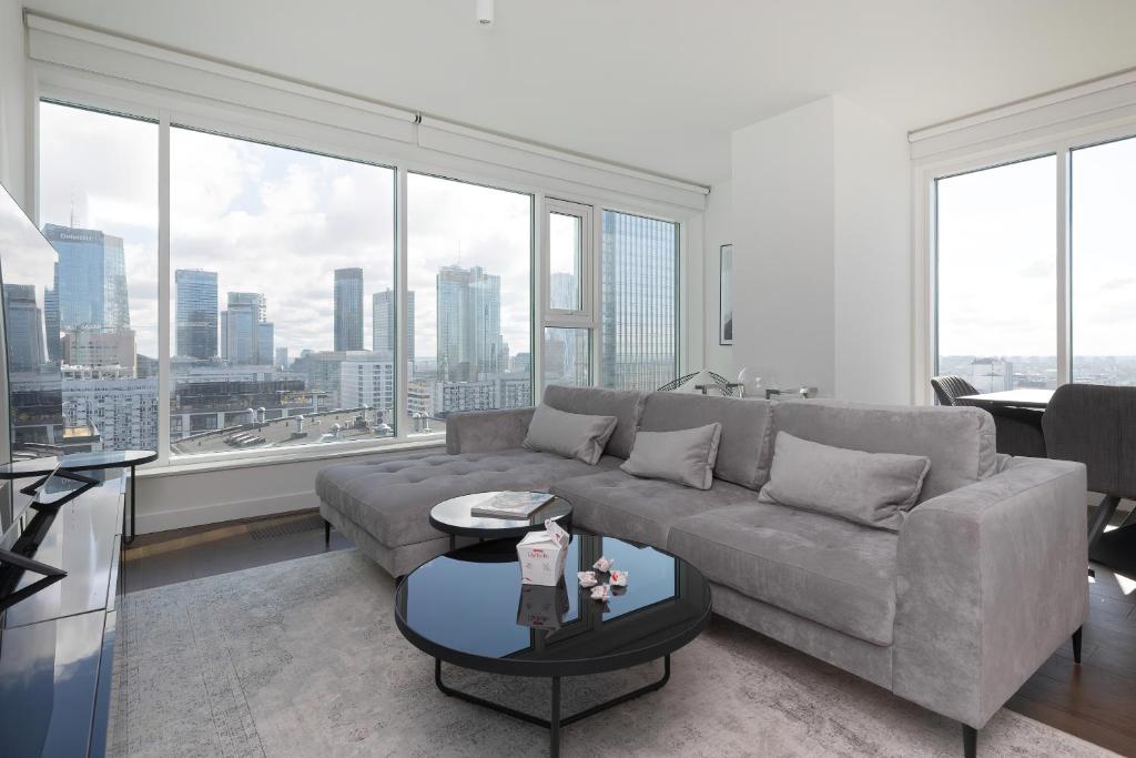 a living room with a couch and large windows at Premium LUX Apartments Unique Tower Heart of Warsaw by Renters Prestige in Warsaw