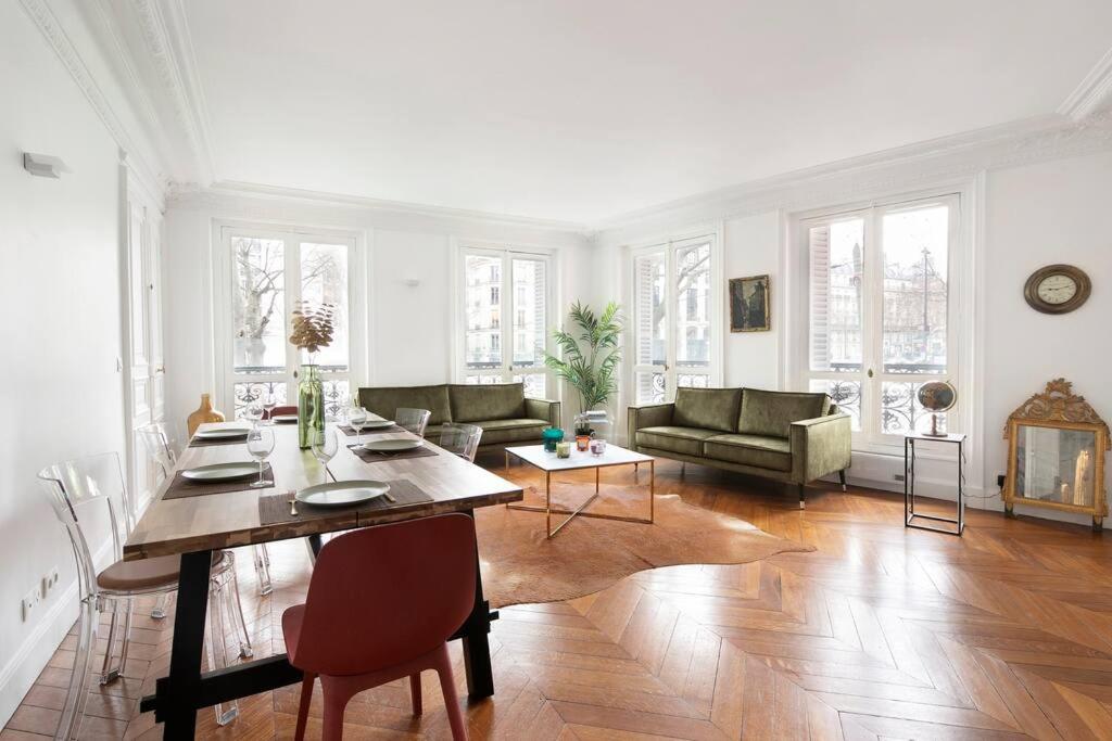 un salon blanc avec une table et un canapé dans l'établissement Sweet Luxury Home Arc the Triomphe near Champs Elysées and Palais des Congrès 8 ppl, à Paris