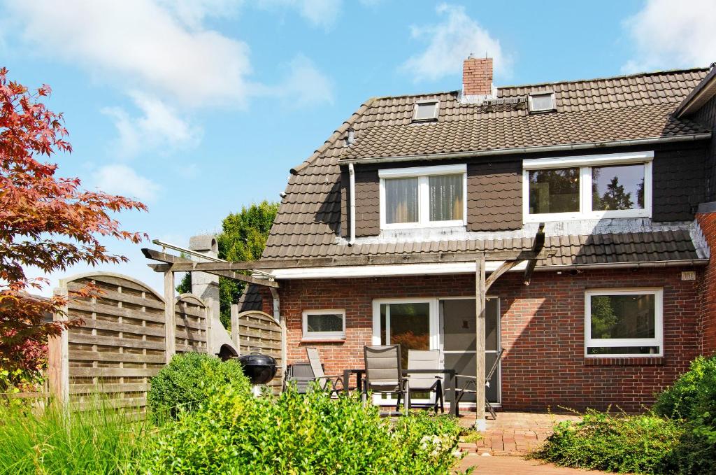 a brick house with a table and chairs in the yard at Fewo am Deich in Wilhelmshaven