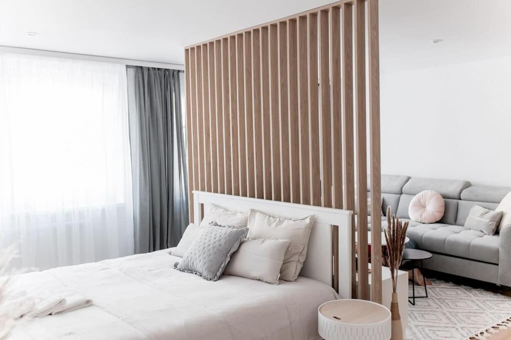 um quarto com uma cama branca e um sofá em Apartament Pastel Room em Leśna