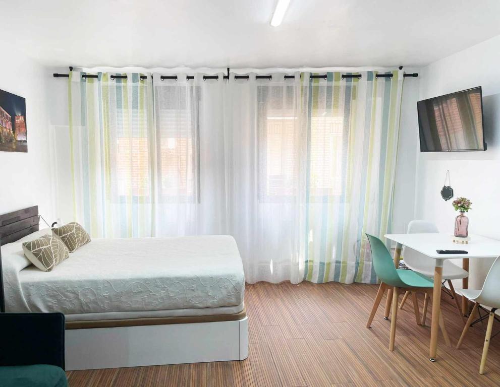 a bedroom with a bed and a table and a desk at Studio Simon 2 Murcia in Murcia
