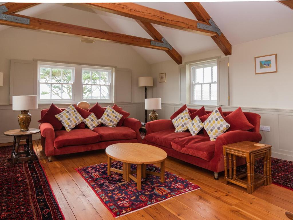 - un salon avec des canapés rouges et une table dans l'établissement Rosecott, à St Ives